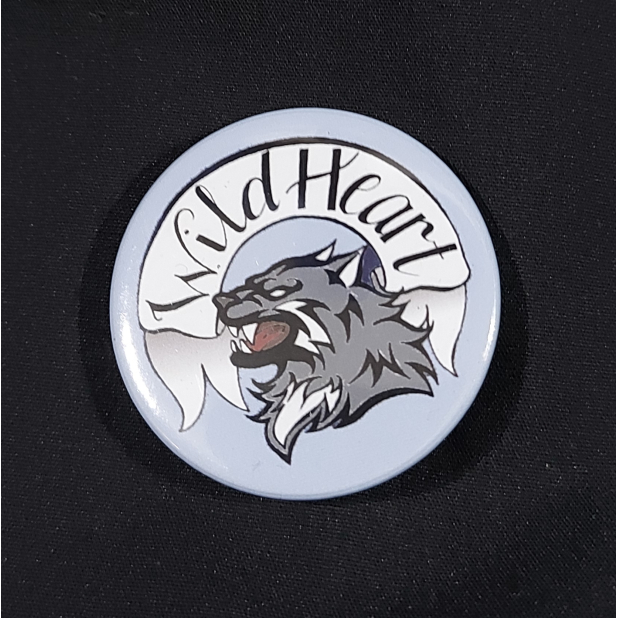 Pinback badge with banner reading "Wild Heart" and a snarling wolf